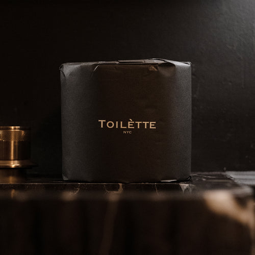Toilet paper roll covered in dark tissue cover with Toilètte branding