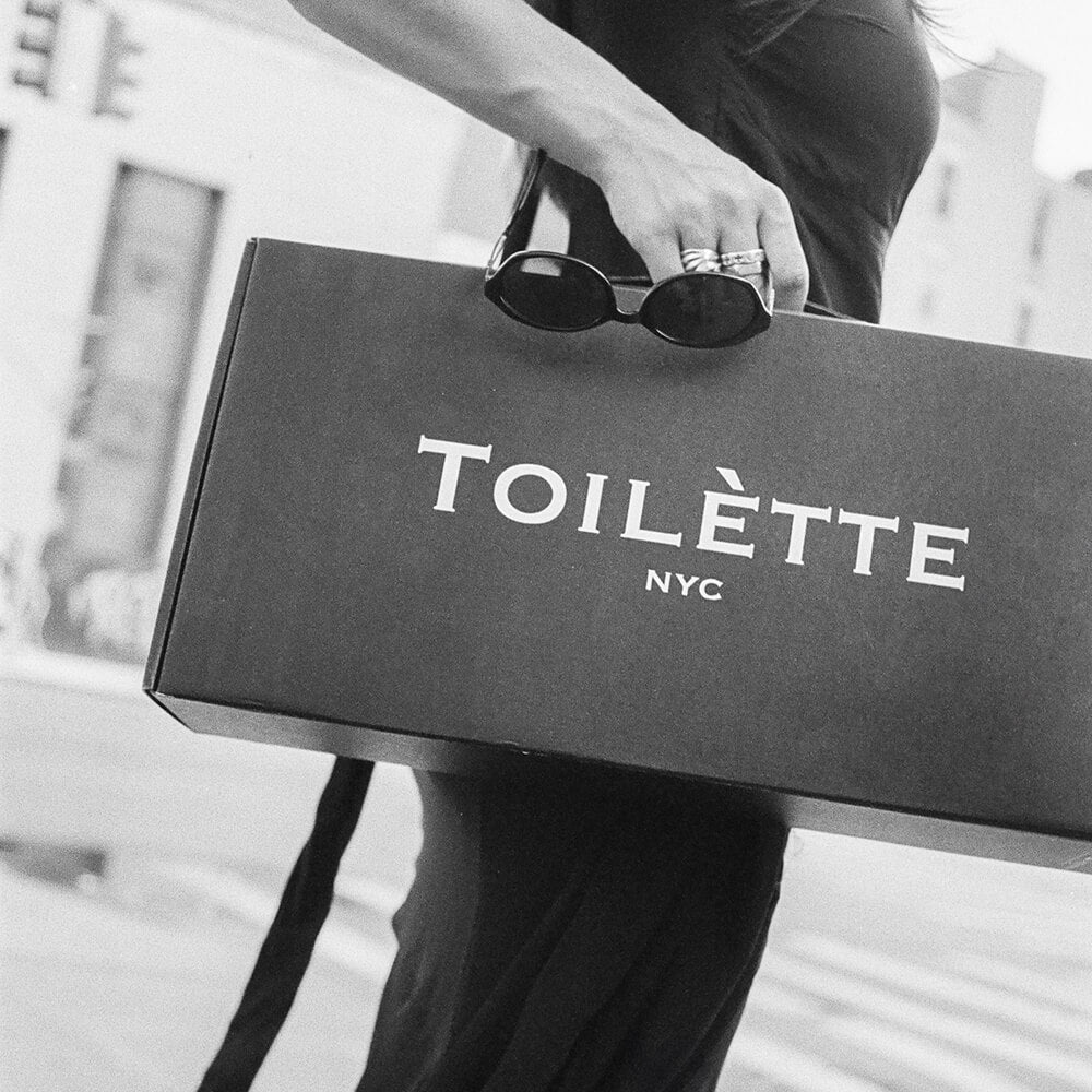 Toilètte box with girl in streets holding glasses